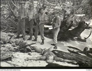 LOS NEGROS ISLAND, ADMIRALTY ISLANDS. 1944-03-18. RAAF GUARDS ON PATROL FOR SNIPERS NEAR THE CAMP AREA AT MOMOTE FIND THE BODY OF A DEAD JAPANESE MARINE ON THE BEACH