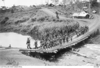 DONADABU, SOGERI VALLEY, NEW GUINEA. 1943-06-28. "A" COMPANY, 61ST INFANTRY BATTALION MARCHING ACROSS THE LALOKI RIVER, ON THEIR WAY OUT OF THE DONADABU TRAINING CAMP FOR A ROUTE MARCH