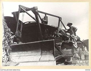 CAPE WOM, WEWAK AREA, NEW GUINEA, 1945-08-24. CORPORAL R. ANDERSON (1) AND WARRANT OFFICER 2 R.H. KEMP (2) MEMBERS OF 2/119 BRIGADE WORKSHOP CORPS OF AUSTRALIAN ELECTRICAL AND MECHANICAL ENGINEERS, ..