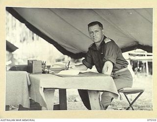 MILILAT, NEW GUINEA. 1944-08-07. NX34766 LIEUTENANT COLONEL A.V. TAYLOR, CHIEF ELECTRICAL AND MECHANICAL ENGINEER, HEADQUARTERS, 5TH DIVISION IN HIS TENT OFFICE