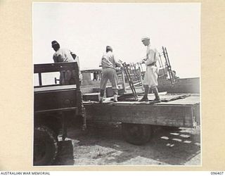 KAIRIRU ISLAND, NEW GUINEA, 1945-09-11. JAPANESE SOLDIERS UNLOADING AND TRANSFERRING THE BELONGINGS OF REAR-ADMIRAL SATO FROM A JAPANESE TO AN AUSTRALIAN TRUCK, DURING THE TRANSFER OF AN ADVANCE ..