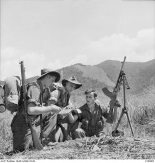 WAU AREA, NEW GUINEA. 1943-08-16. MEN OF HEADQUARTERS, 17TH AUSTRALIAN INFANTRY BRIGADE, CASTING THEIR VOTES IN THE FEDERAL ELECTION, BEFORE MOVING TO THE FRONT LINE. LEFT TO RIGHT:- SX25418 ..