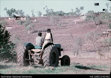 Men riding a tractor