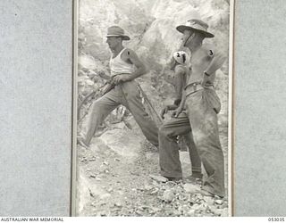 PORT MORESBY, NEW GUINEA. 1943-06-26. ENGINEERS DRILLING CHARGE HOLES IN QUARRY FACE. LEFT TO RIGHT:- SAPPER J.W. RIORDEN, 2/1ST AUSTRALIAN MECHANICAL ENGINEERS COMPANY; NX99111 SAPPER T. GEAREN, ..