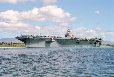 Port bow view of the nuclear-powered aircraft carrier USS ABRAHAM LINCOLN (CVN 72) moving down the channel from Pearl Harbor. The ship is departing to take part in Operation RIMPAC 2000