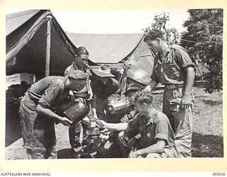 WEWAK POINT, NEW GUINEA. 1945-08-29. PRIVATE TRELOAR, NO. 16 PLATOON, D COMPANY, 2/8 INFANTRY BATTALION POURING TEA FOR HIS MATES