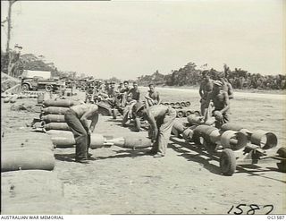 TADJI NEAR AITAPE, NORTH EAST NEW GUINEA. C. 1944-10. BOMBS BEING LOADED ONTO TRAILERS FROM A DUMP NEAR AITAPE ARE HAULED TO WAITING BEAUFORT BOMBER AIRCRAFT. A RAAF SQUADRON BASED IN THE AREA ..