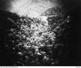 WIDE BAY, NEW GUINEA. 1943-12-16. A SMOKE SIGNAL IS USED TO GUIDE AN AIRCRAFT SUPPLY DROP. (NAVAL HISTORICAL COLLECTION)