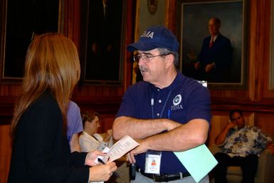 [Earthquake] Honolulu, HI, October 31, 2006- FEMA Federal Coordinating Officer Mike Karl speaks with a Red Cross Official at The Hawaii State Capitol prior to a press conference regarding recovery from the October 15 earthquake and aftershocks. Adam DuBrowa/FEMA.