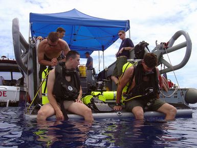 U.S. Navy LT. j.g. Tyler Y. Smith and Navy Diver Third Class Zach D. Dimare, from the Rescue and Salvage Ship USS SAFEGUARD (ARS 50), inspect their diving gear and test communications prior to entering the water on Oct. 10, 2006, to survey two U.S. Douglas Torpedo Bomber Devastators lost here in World War II. Divers and other crewmembers from SAFEGUARD assisted the Naval Historical Center and The International Group for Historic Aircraft Recovery in a scientific survey of the two submerged World War II aircraft in order to provide information for possible salvage in the future. U.S. Navy photo by Navy Diver Second Class Morgan B. Wade (Released)