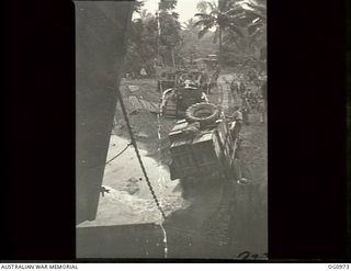 AITAPE AREA, NORTH EAST NEW GUINEA. C. 1944-04-22. SUPPLY TRUCKS AND ROAD BUILDING HEAVY EQUIPMENT COMES ASHORE FROM A LANDING SHIP, TANK (LST) AT KORAKO VILLAGE