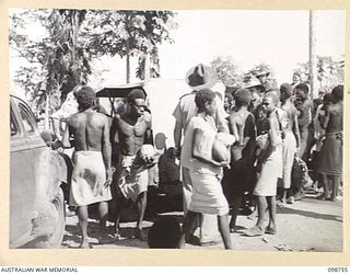 RABAUL, NEW BRITAIN. 1945-11-10. FRUIT BEING PLACED INTO JEEPS BY NATIVES FOR THEIR CUSTOMERS AT THE NATIVE MARKET AT TALILI BAY IN 4 INFANTRY BRIGADE AREA