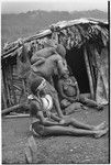 Bride price ritual: bride wearing large shell valuables sits with other women and small children