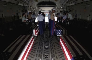 During a commemorative ceremony at Hickam Air Force Base (AFB) Hangar 35, inside a US Air Force (USAF) C-17A Globemaster III, members of a joint honor guard prepare to carry the remains believed to be of unaccounted-for Americans, recovered in Vietnam and Papua New Guinea. The remains will be taken to the Joint POW/MIA Accounting Command's Central Identification Laboratory (JPAC CIL) where they will attempt to positively identify the remains so they can be returned to their families