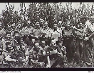 WAU, NEW GUINEA. 1943-08-9-12. WARRANT OFFICER J. H. WINSTANLEY OF THE AUSTRALIAN ARMY EDUCATION SERVICE, CONDUCTS A CHOIR AT BULOLO. HE HAS TAUGHT THE MEN BOTH SINGING AND MUSIC READING