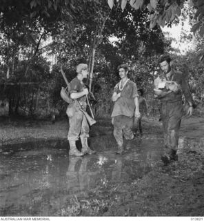 1942-11-23. NEW GUINEA. OIVI. WALKING WOUNDED ON THEIR WAY BACK BACK TO DRESSING STATION. (NEGATIVE BY G. SILK)