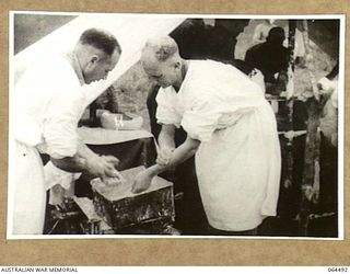 MELBOURNE, VICTORIA, AUSTRALIA. 1944-03-03. COPY OF A SCENE FROM A CINE STRIP OF TWO DOCTORS PREPARING THEMSELVES FOR AN OPERATION AT A FIELD DRESSING STATION SOMEWHERE IN NEW GUINEA