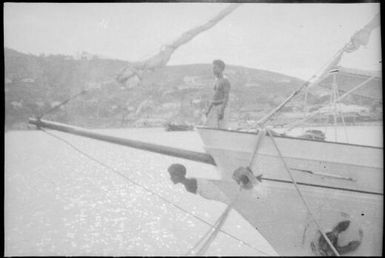 Man standing in the prow of the government vessel  Laurabada, Papua, ca. 1923 / Sarah Chinnery