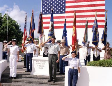 Members of a joint services honor guard salute as the national anthem is played during a Veteran's Day memorial service at the Tomb of the Unknown Soldier, located in Skinner Plaza