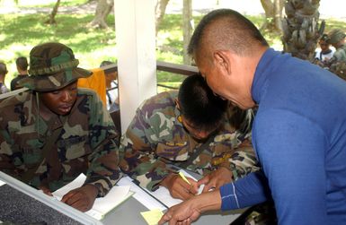 US Marine Corps (USMC) Lance Corporal (LCPL) Byron Martin, left and Royal Thai Marine Sergeant (SGT) Sayun Thangtong, use the Non-Combatant Evacuation Operation (NEO) tracking system to processes Evacuees during a NEO, part of Exercise COBRA GOLD 2003. Lance Corporal (LCPL) Byron Martin, is attached to the 3rd Brigade Service Support Group from Kaneohe Bay, Hawaii