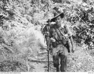 KETOBA, NEW GUINEA. 1944-01-29. VX81108 LIEUTENANT P.B. NINK (1) FOLLOWED BY CORPORAL C.F.P. ROBERTS (2) LEAD FULLY EQUIPPED MEMBERS OF "B" COMPANY 57/60TH INFANTRY BATTALION, ALONG A TRAIL AT THE ..