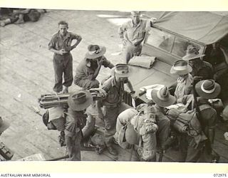 LANGEMAK BAY, NEW GUINEA. 1944-04-23. TROOPS OF THE 5TH DIVISION PASS CHECKING OFFICERS BEFORE BOARDING THE AMERICAN LIBERTY SHIP DAVID E. HUGHES FOR THE JOURNEY TO SAIDOR