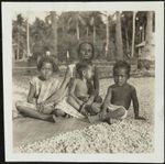 Nauruans Tuti, Pin and two grandchildren sitting on a mat on the sand, Nauru, April 1935 / Camilla Wedgwood