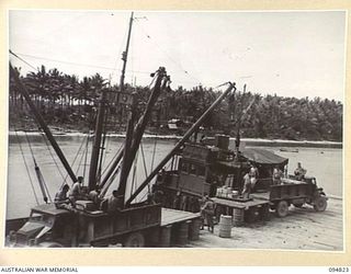 TOL PLANTATION, NEW BRITAIN, 1945-08-04. PERSONNEL OF 28 INFANTRY BATTALION UNLOADING AN AMERICAN FIELD SERVICE TYPE SHIP AT TOL WHARF. TWO UNITED STATES BOATS ARE NOW RUNNING A SERVICE BETWEEN TOL ..