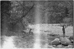 Simbai River Valley: men and boy relax on bank of a large river