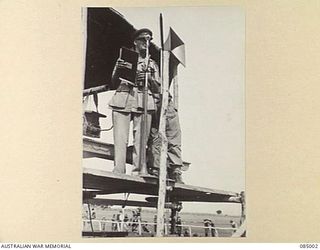 KAIRI, ATHERTON TABLELAND, QLD. 1944-12-25. CAPTAIN C.A. MARSH, 2/10 INFANTRY BATTALION GIVING THE STARTERS IN THE FINISTERRE STAKES DURING THE RACE MEETING HELD AT KAIRI SPORTS GROUND. A ..