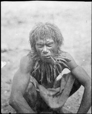 Papuan man from the bush wearing a fern collar and smoking a European pipe, Papua, ca. 1923, 2 / Sarah Chinnery