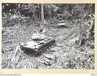 TOROKINA, BOUGAINVILLE, 1945-07-03. A SECOND TANK ATTEMPTING TO PULL A BOGGED M24 GENERAL CHAFFEE LIGHT TANK FROM THICK MUD DURING TESTS CONDUCTED FOR THE WAR OFFICE