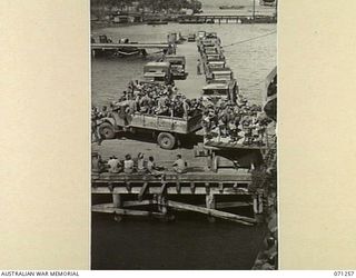 MILNE BAY, PAPUA, 1944-03-15. TROOPS DISEMBARK FROM HT TAROONA AT LYAL WHARF AFTER COMPLETING VOYAGE 49. THE LINE OF DOTS TO THE REAR OF REPULSE WHARF IN THE MIDDLE DISTANCE IS THE SUBMARINE BOOM. ..