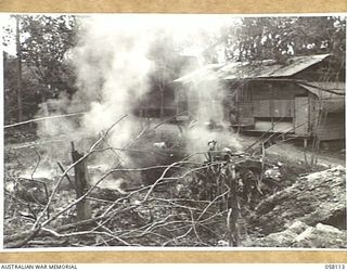 FINSCHHAFEN, NEW GUINEA, 1943-10-02. FIRES, BURNING RUBBISH NEAR CAPTURED JAPANESE HUTS DURING THE CLEANING UP OF THE AREA BY TROOPS OF THE 9TH AUSTRALIAN DIVISION