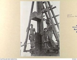 MINGA CREEK, WEWAK AREA, NEW GUINEA. 1945-05-30. SAPPERS OF 2/8 FIELD COMPANY ROYAL AUSTRALIAN ENGINEERS, USING A PORTABLE PILE DRIVER DURING BRIDGE BUILDING CONSTRUCTION. THE "DOLLY" IS RAISED TO ..