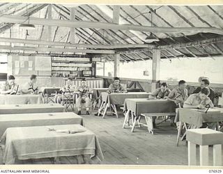 LAE, NEW GUINEA. 1944-11-18. PERSONNEL OF THE 18TH FIELD AMBULANCE RELAXING IN THEIR RECREATION HUT. IDENTIFIED PERSONNEL ARE:- CORPORAL T.W. PETERS (1); LANCE CORPORAL J. MARMONT (2); PRIVATE L. ..