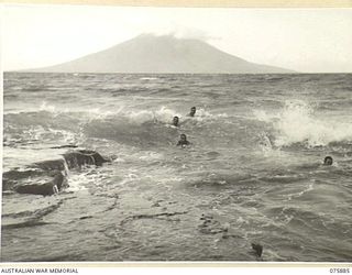 POTSDAM, NEW GUINEA. 1944-09-05. OFFICERS OF THE 25TH INFANTRY BATTALION ENJOYING A SWIM IN THE HEAVY SURF NEAR THEIR CAMP. NOTE MANAM ISLAND IN THE BACKGROUND. THIS VOLCANIC ISLAND IS ACTIVE AND ..