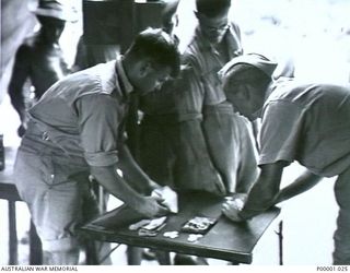 THE SOLOMON ISLANDS, 1945-01-12. HIGH FINANCE AT A COMBINED ANZAC SPORTS MEETING AT BOUGAINVILLE ISLAND. (RNZAF OFFICIAL PHOTOGRAPH.)