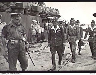 TOROKINA, BOUGAINVILLE. 1945-09-08. LIEUTENANT-GENERAL M. KANDA, COMMANDER, 17TH JAPANESE ARMY AND VICE ADMIRAL BARON SAMEJIMA, IMPERIAL JAPANESE NAVY, WALKING ALONG THE PONTOON WHARF AFTER ..