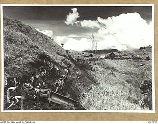 LAKE ROAD, FINISTERRE RANGES, NEW GUINEA. 1943-12-21. TROOPS OF THE 2/14TH AUSTRALIAN INFANTRY BATTALION AND PERSONNEL OF THE ROYAL AUSTRALIAN ENGINEERS, 7TH AUSTRALIAN DIVISION WORKING ON THE ..