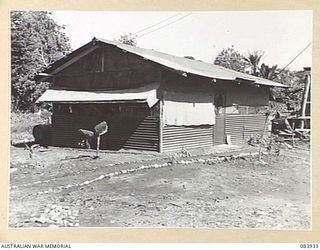 LAE, NEW GUINEA. 1944-12-12. THE COOK HOUSE AND THE MESS AT THE ARMY CANTEENS SERVICE SOFT DRINK FACTORY, LAE BASE SUB-AREA. THE PATHS ARE NEATLY LAID WITH CINDERS FROM THE BOILER WHICH IS FED WITH ..