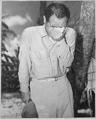 Japanese Prisoner of War at Guam, with bowed head after hearing Emperor Hirohito make announcement of Japan's unconditional surrender.