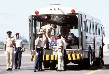 Combined services pallbearers place the flag draped casket of a former Missing In Action (MIA) person into a bus during a ceremony on the flight line. Fifteen former American MIAs from Southeast Asia are arriving at the base for positive identification by the Army Central Identification Laboratory