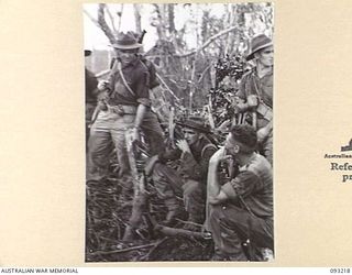 WEWAK AREA, NEW GUINEA, 1945-06-16. LT E.J. MARTIN, PLATOON COMMANDER, D COMPANY, 2/8 INFANTRY BATTALION (1), ISSUING INSTRUCTIONS TO A PATROL PRIOR TO LEAVING THE B COMPANY AREA. IDENTIFIED ..