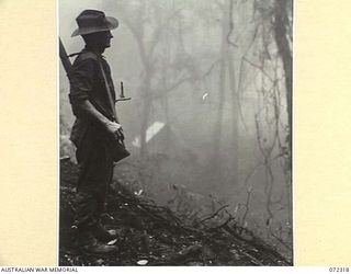 YAULA, NEW GUINEA. 1944-04-12. Q138896 PRIVATE L.C. ORAN, 57/60TH INFANTRY BATTALION STANDING GUARD IN EARLY MORNING FOG NEAR AIYAN
