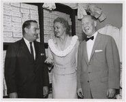 Priest, center, with Jack Benson (left), commentator for KGMB-TV, and Carl E. Hanson (right), President, Bishop National Bank of Hawaii, with packages labeled Silver Certificates in the background, on May 6, 1959