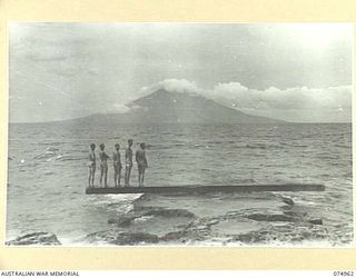 HANSA BAY, NEW GUINEA. 1944-07-29. TROOPS OF THE 30TH INFANTRY BATTALION COOLING OFF AT THE BEACH NEAR THEIR CAMP IN THE POTSDAM PLANTATION. IN THE BACKGROUND CAN BE SEEN MANAM ISLAND, A 4000 FEET ..