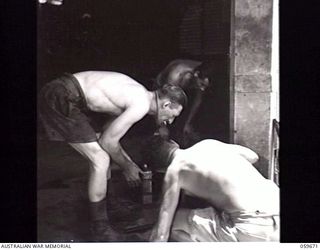 BOMANA, NEW GUINEA. 1943-11-08. VX45793 SERGEANT G. H. RALPH (LEFT), NCO IN CHARGE AND AN ENGINEER N228327 SAPPER J. F. DAY DOING MAINTENANCE ON THE BOMANA PUMPING STATION EQUIPMENT. THIS UNIT ..