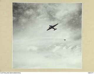 NADZAB, NEW GUINEA. 1944-07-21. A DOUGLAS C47 DAKOTA TRANSPORT AIRCRAFT DROPPING UNPROTECTED SUPPLIES TO DETERMINE THE EFFECTIVENESS OF STORPEDO CONTAINERS IN SUPPLY DROPS TO HEADQUARTERS NEW ..