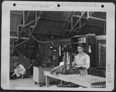 A Rockwell hardness tester is operated by a member of the 27th Air Depot Group at the Port Moresby Air Depot, Papua, New Guinea. 25 October 1943. (U.S. Air Force Number 67700AC)